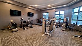 Lino Lakes apartment for rent - a gym with treadmills and other exercise equipment in a building with large windows