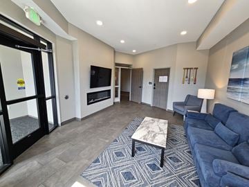 Melrose apartment for rent - A living room with a blue couch and a television.