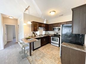 Sartell townhouse for rent - a kitchen with stainless steel appliances and a bar with a counter top