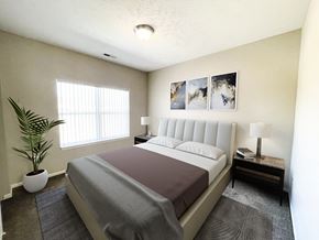 Sartell townhouse for rent - a bedroom with a bed and a plant