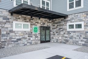 Dodge Center apartment for rent - a stone building with a glass door and a green sign on it