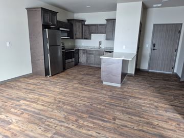 New York Mills apartment for rent - A kitchen with a black refrigerator and wooden floors.