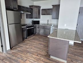 New York Mills apartment for rent - A kitchen with a refrigerator, oven, and microwave.