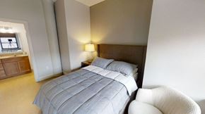 Duluth apartment for rent - a white bed in a room with geometric wallpaper