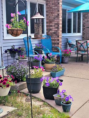 Big Lake apartment for rent - a front porch with pots of flowers and chairs on it