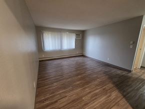 St Cloud apartment for rent - A room with wooden flooring and a window with blinds.
