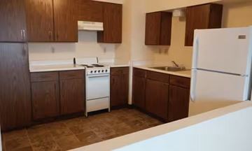 Anoka apartment for rent - A kitchen with brown cabinets and a white refrigerator.