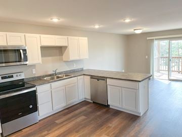 Cambridge apartment for rent - A kitchen with white cabinets and a wooden floor.