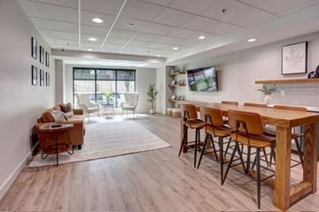 Rochester apartment for rent - A modern living room with a wooden dining table and chairs.