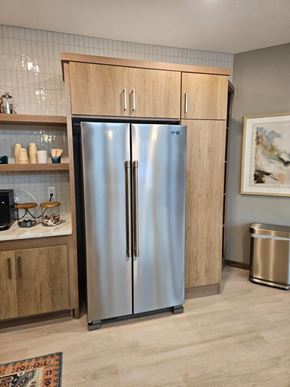Alexandria apartment for rent - A stainless steel refrigerator with wooden cabinets and a trash can in a kitchen.