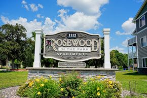 St Cloud apartment for rent - A sign for Rosewood Apartments is displayed in front of a building.