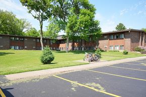 Milaca apartment for rent - A parking lot in front of a building with a bicycle parked.