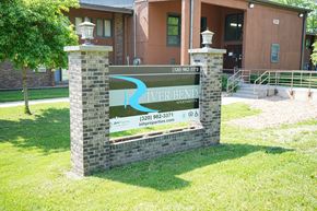 Milaca apartment for rent - A sign for River Bend Apartments stands in front of a building.