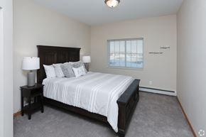 East Bethel apartment for rent - A bedroom with a large bed and two lamps.