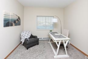 East Bethel apartment for rent - A room with a table, chair, and a painting on the wall.