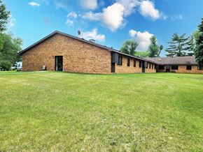 Twin Valley apartment for rent - A large grassy field in front of a brick building.