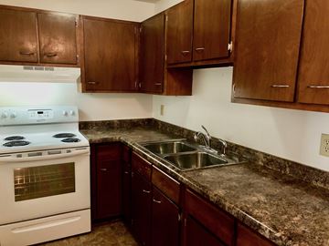 Morris apartment for rent - A kitchen with a white stove and brown cabinets.