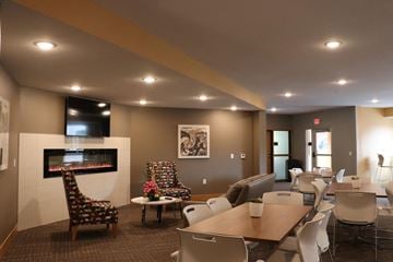 Maplewood apartment for rent - a large living room with a fireplace and tables and chairs