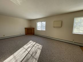 Fergus Falls apartment for rent - A room with a carpeted floor and a wooden door.