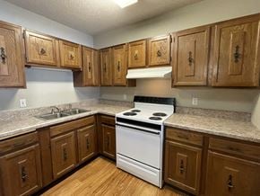 Twin Valley apartment for rent - A kitchen with wooden cabinets and a white stove top oven.
