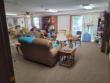 Hawley apartment for rent - A living room with a brown couch and a table with a vase of flowers on it.