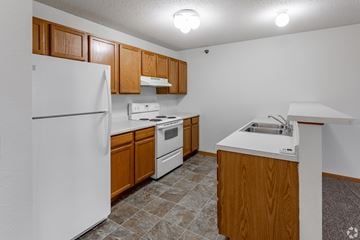 Isanti apartment for rent - A kitchen with white appliances and wooden cabinets.