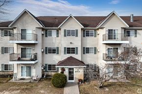 Isanti apartment for rent - BLDG A/C - Apartment building with balconies and a small entrance garden.