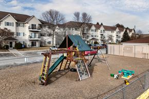 Isanti apartment for rent - BLDG A/C - A playground with a green slide and a red car.