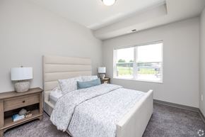 Clear Lake apartment for rent - A bedroom with a large bed and a window overlooking a parking lot.