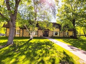 Little Falls apartment for rent - A house with a green lawn and trees in front.