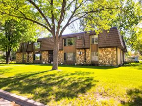 Little Falls apartment for rent - A house with a brown roof and a tree in front of it.