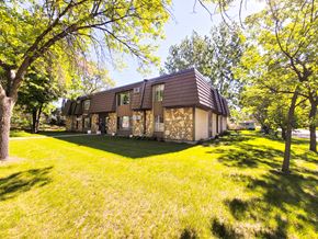 Little Falls apartment for rent - A house with a brown roof is surrounded by green grass and trees.