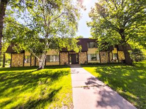 Little Falls apartment for rent - A house with a yellow front and a tree in front of it.