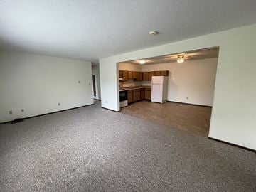 Little Falls apartment for rent - A sparsely furnished living room with a kitchen in the background.