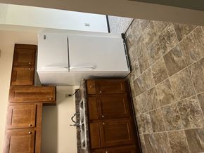 Brainerd apartment for rent - A white refrigerator is installed in a kitchen with brown cabinets.