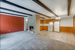 Sartell apartment for rent - A living room with a fireplace and a kitchen area in the background.