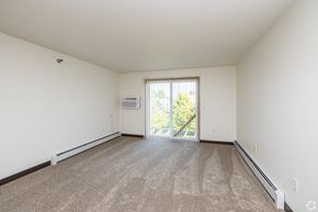 Byron apartment for rent - A spacious room with a carpeted floor and a sliding glass door leading to a balcony.