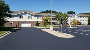 Mankato apartment for rent - A parking lot in front of a building with a clear blue sky.