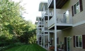 Mankato apartment for rent - A building with a balcony overlooking a green lawn.