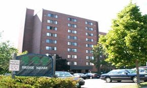 Anoka apartment for rent - outside of building with bridge square sign