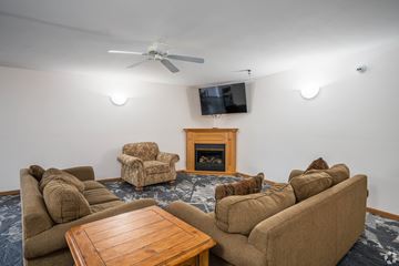 Apple Valley apartment for rent - A living room with a fireplace and a television mounted on the wall.