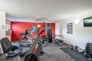 Apple Valley apartment for rent - A home gym with a red wall and a variety of exercise equipment.