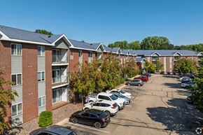 Apple Valley apartment for rent - A parking lot with cars and apartment buildings in the background.
