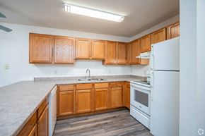 Apple Valley apartment for rent - A kitchen with wooden cabinets and a white refrigerator.