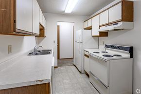 Elk River apartment for rent - A kitchen with white appliances and wooden cabinets.