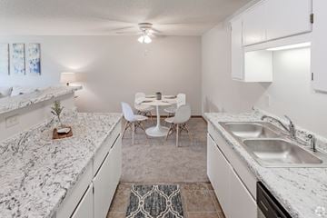 St Cloud apartment for rent - A kitchen with a marble countertop and white cabinets.
