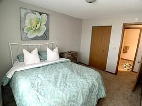St Cloud apartment for rent - A bedroom with a bed, nightstand, and a painting of a flower on the wall.