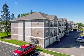 Owatonna apartment for rent - A red truck is parked in a parking lot in front of a building.