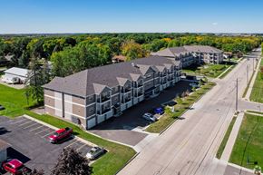 Owatonna apartment for rent - A large building with a parking lot in front of it.