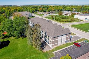 Owatonna apartment for rent - A large building with a parking lot in front of it.